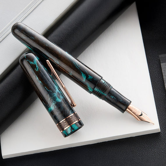 A Conklin 1898 fountain pen showcasing a beautiful green, blue, and brown resin body. The pen has rose gold nib, decorative rose gold band at the base of the cap, and a rose gold 