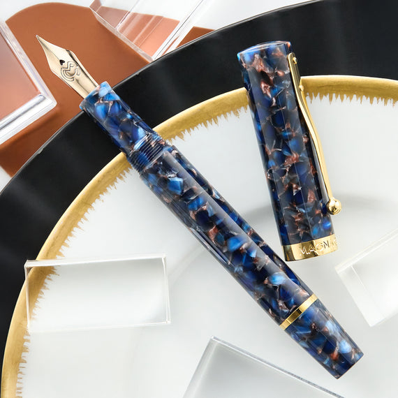 Fountain pen with decorative cap on a white plate