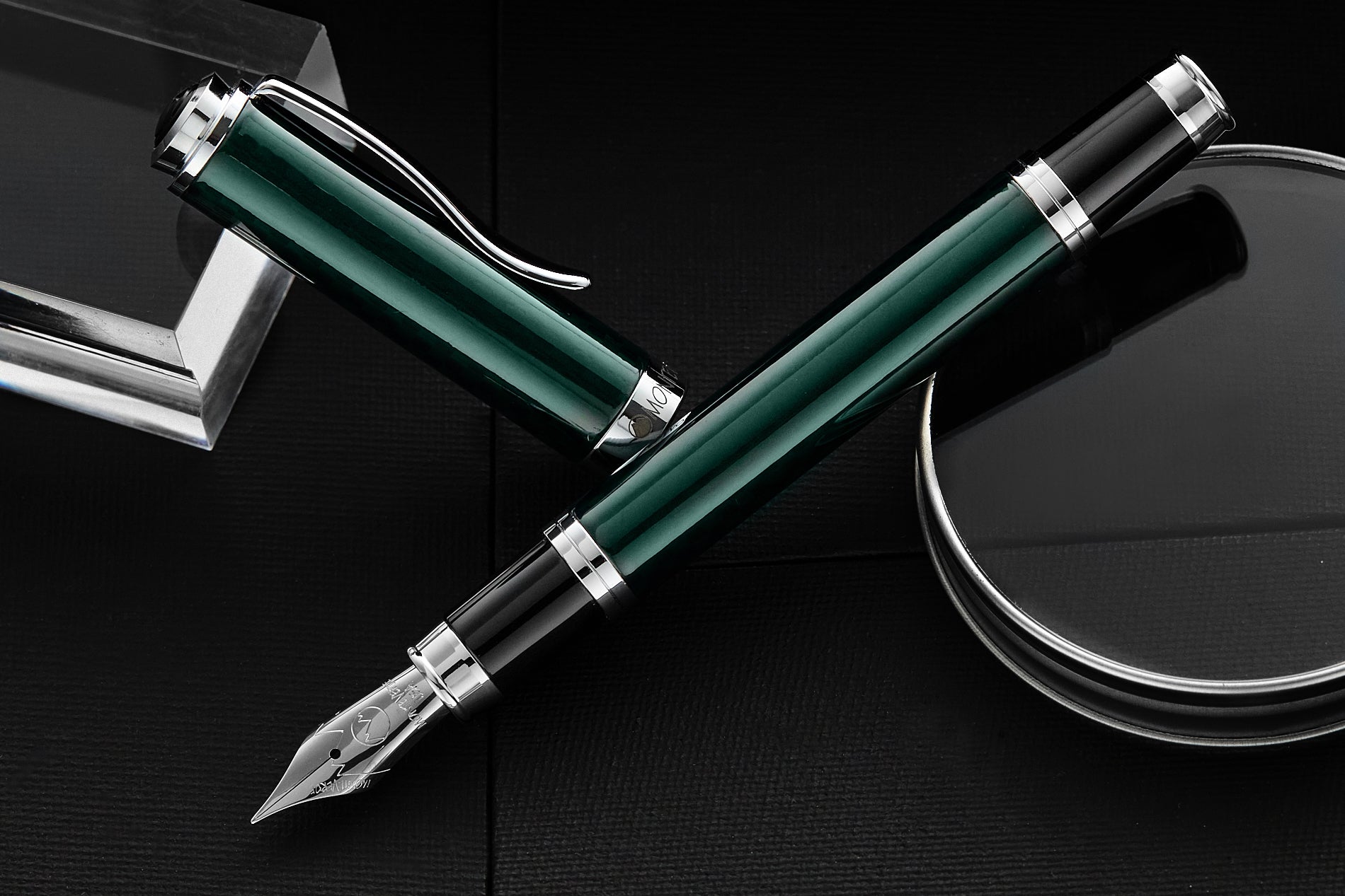 Monteverde Green Carbon Fiber fountain pen uncapped on black mirrored desktop